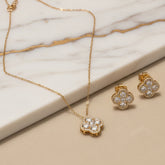 Gold necklace with a textured pendant on a blue striped fabric background