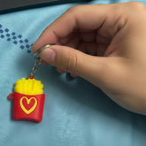 Keychain with a container of fries on a blue fabric background