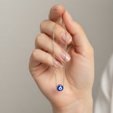 Necklace with a blue pendant inside a 'Rärest' branded box on a blue fabric background